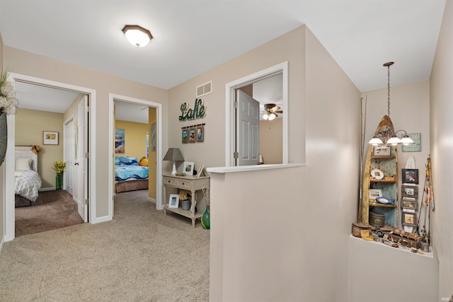 hallway with an inviting chandelier and carpet