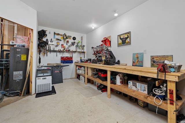 miscellaneous room with a workshop area, electric water heater, and concrete flooring