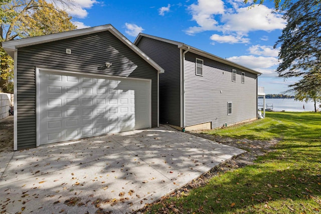 exterior space with a water view, a garage, and a yard