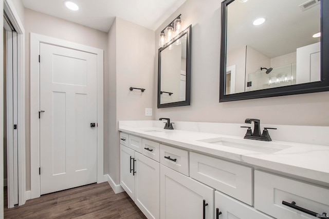 bathroom featuring walk in shower, vanity, and hardwood / wood-style flooring