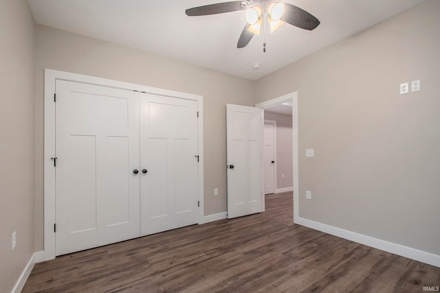 unfurnished bedroom with ceiling fan, dark wood-type flooring, and a closet