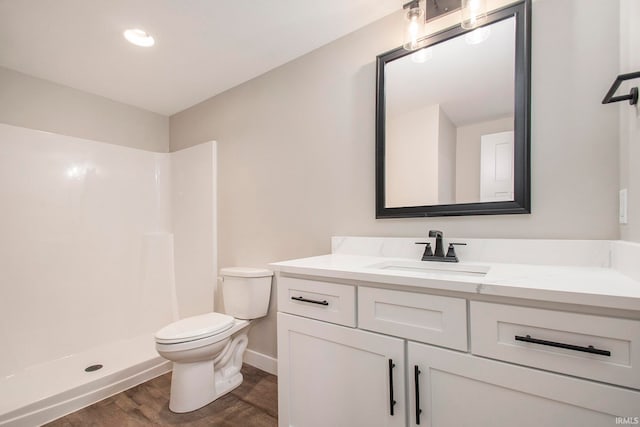 bathroom with a shower, hardwood / wood-style flooring, vanity, and toilet