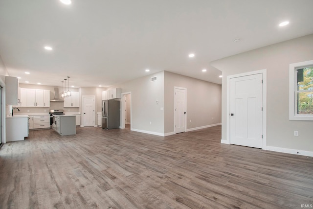 unfurnished living room with sink and hardwood / wood-style floors