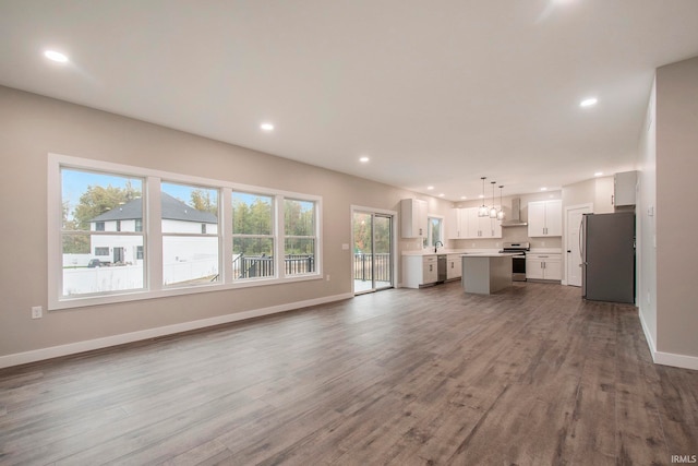 unfurnished living room with a wealth of natural light and hardwood / wood-style floors