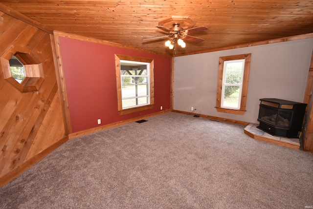 unfurnished living room featuring a wood stove, a wealth of natural light, vaulted ceiling, and wood ceiling