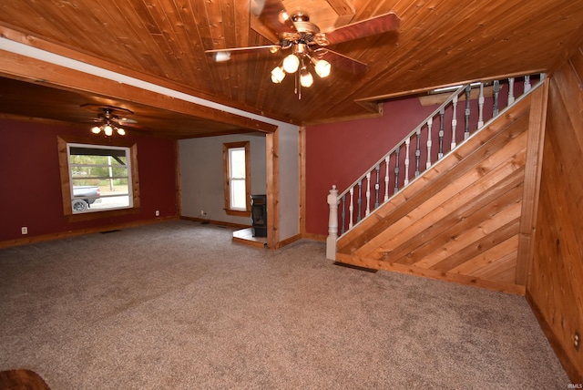 unfurnished living room featuring wooden walls, ceiling fan, carpet floors, and wood ceiling