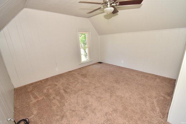 bonus room featuring ceiling fan, wooden walls, vaulted ceiling, and carpet