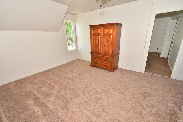 unfurnished bedroom with light carpet and lofted ceiling