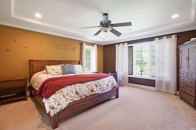 carpeted bedroom featuring ceiling fan, a tray ceiling, and crown molding