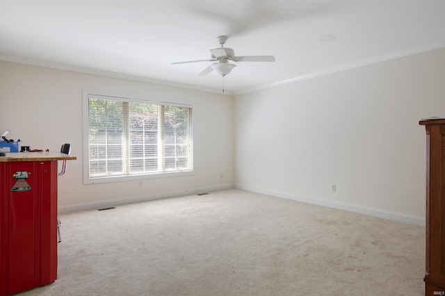 carpeted spare room featuring ornamental molding and ceiling fan