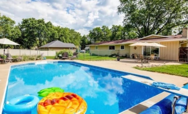 view of pool with a patio area and a diving board