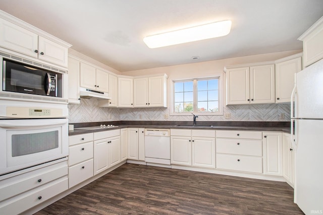 kitchen featuring white appliances, dark wood-type flooring, sink, and white cabinets