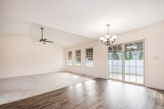 spare room with a wealth of natural light, vaulted ceiling, hardwood / wood-style flooring, and ceiling fan with notable chandelier