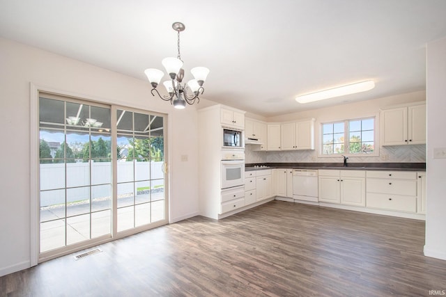 kitchen featuring white appliances, decorative backsplash, and dark hardwood / wood-style flooring