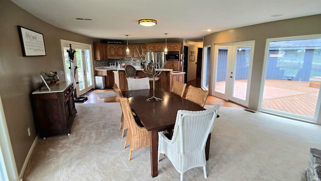 carpeted dining space featuring french doors