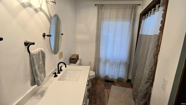 bathroom featuring vanity, toilet, and hardwood / wood-style flooring