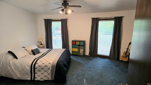 carpeted bedroom featuring multiple windows and ceiling fan