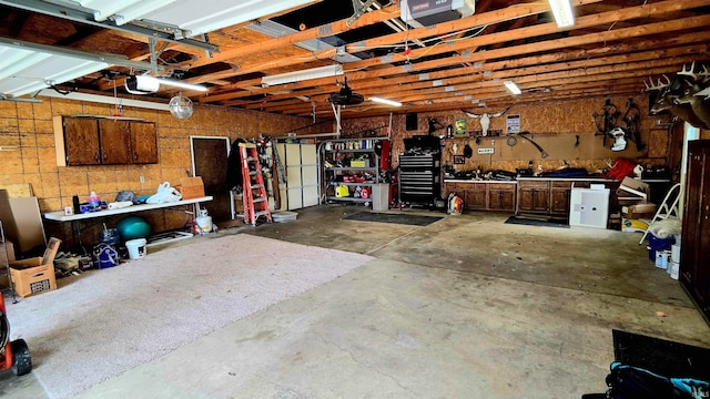 garage with a garage door opener and a workshop area