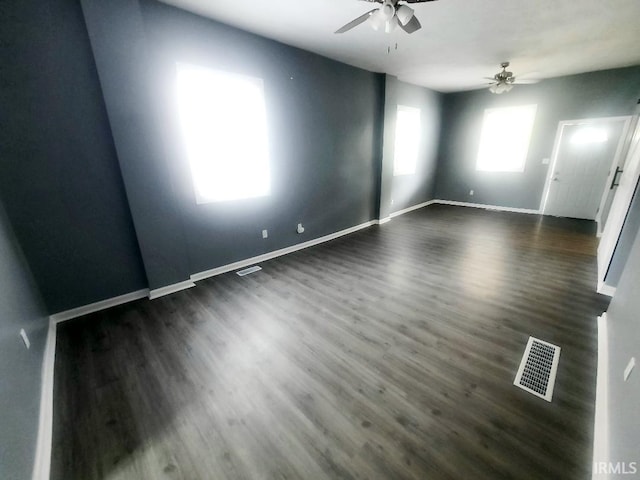 empty room featuring dark wood-type flooring and ceiling fan