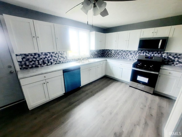 kitchen with decorative backsplash, white cabinets, light hardwood / wood-style flooring, sink, and stainless steel appliances