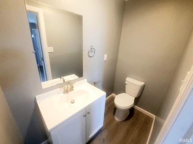 bathroom with vanity, toilet, and hardwood / wood-style floors