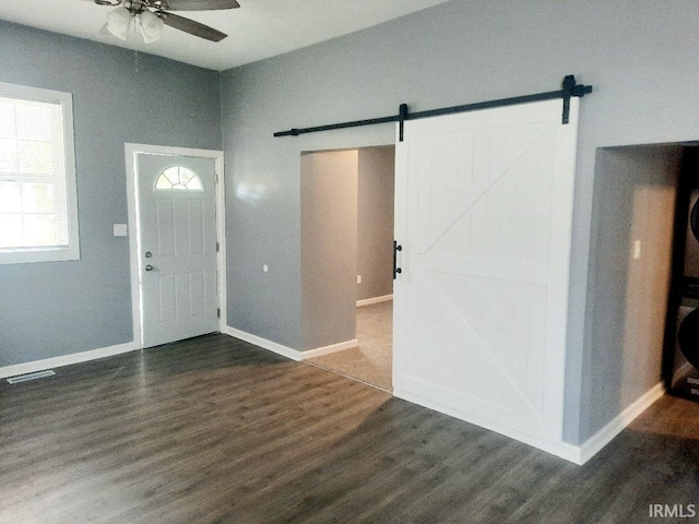 entrance foyer featuring dark hardwood / wood-style floors, a barn door, and ceiling fan