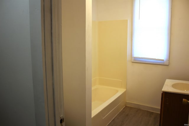 bathroom featuring hardwood / wood-style floors, a tub to relax in, and vanity