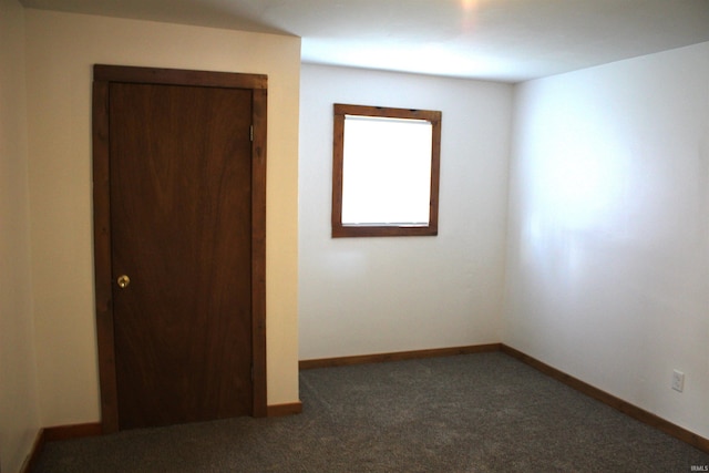 empty room featuring dark carpet