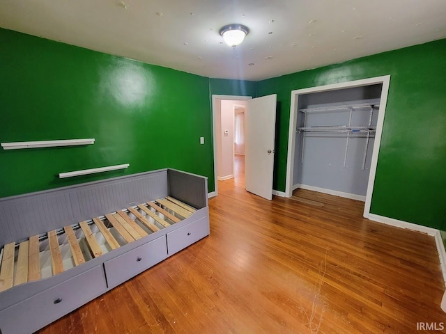 unfurnished bedroom with a closet and wood-type flooring