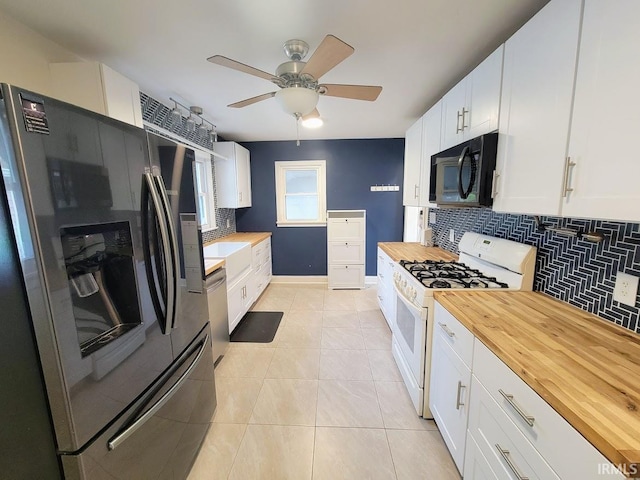 kitchen with light tile patterned flooring, tasteful backsplash, butcher block countertops, white cabinetry, and stainless steel appliances