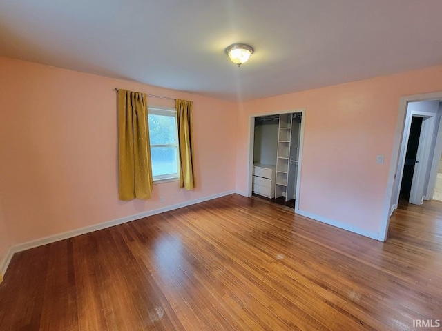 unfurnished bedroom with hardwood / wood-style flooring and a closet