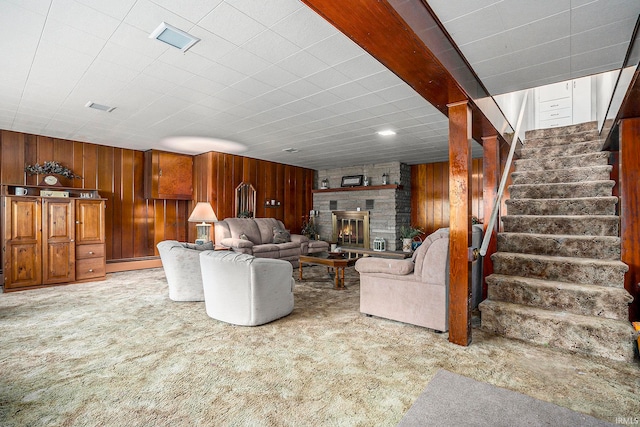 living room with a baseboard radiator, wooden walls, a fireplace, and carpet