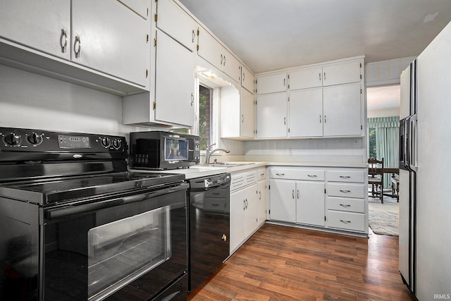 kitchen with white cabinetry, black appliances, dark hardwood / wood-style flooring, and sink