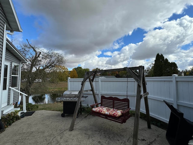 view of patio with a water view and area for grilling