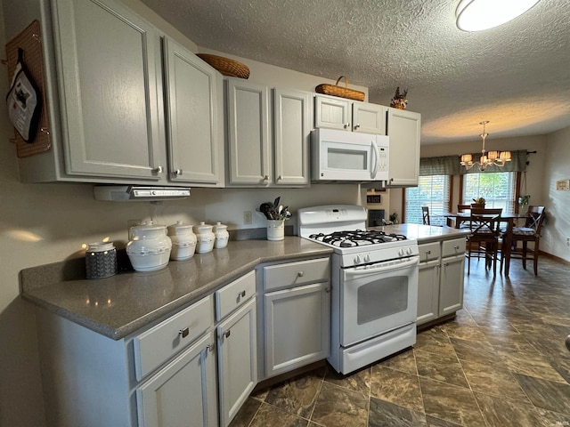 kitchen with white appliances, hanging light fixtures, a notable chandelier, and a textured ceiling