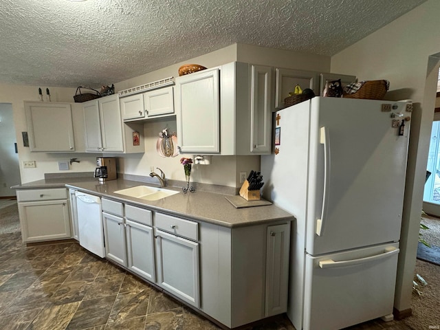 kitchen featuring white appliances, sink, and a textured ceiling