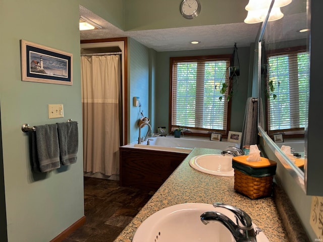 bathroom featuring separate shower and tub, vanity, wood-type flooring, and a textured ceiling