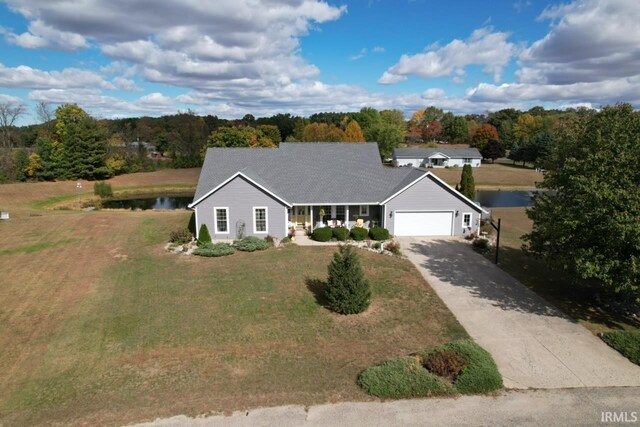 ranch-style home with a garage, a front lawn, and a water view