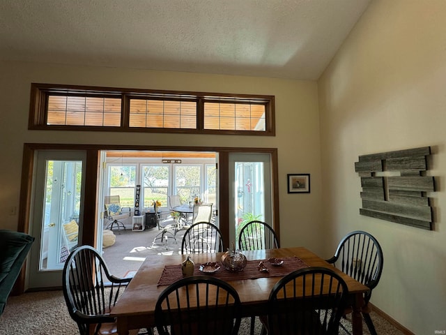 dining area with high vaulted ceiling, french doors, carpet, and a textured ceiling