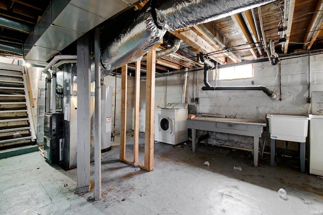 basement with gas water heater, heating unit, and washing machine and dryer