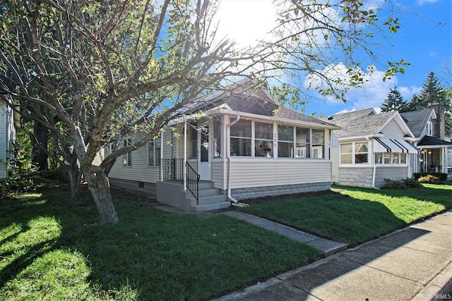 bungalow-style house with a sunroom and a front lawn