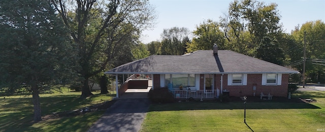 view of front facade with a carport, covered porch, and a front yard