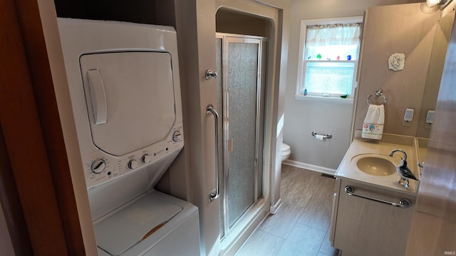 laundry area featuring stacked washing maching and dryer and sink