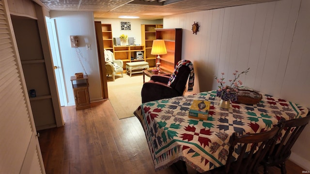 bedroom with hardwood / wood-style flooring and wooden walls