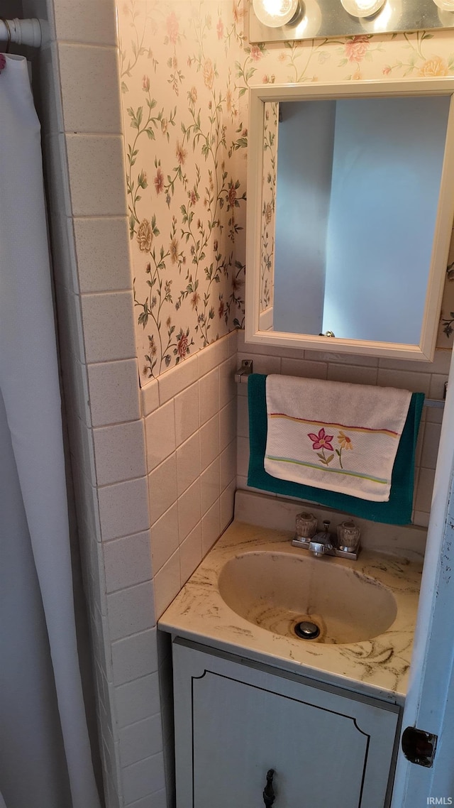 bathroom with vanity and tile walls