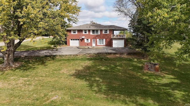 rear view of property with a garage and a yard