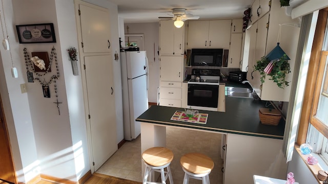 kitchen featuring ceiling fan, sink, decorative backsplash, white cabinets, and black appliances