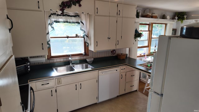 kitchen featuring sink, white cabinetry, white appliances, and a healthy amount of sunlight