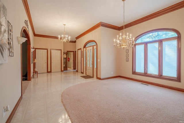 carpeted empty room featuring ornamental molding and a chandelier