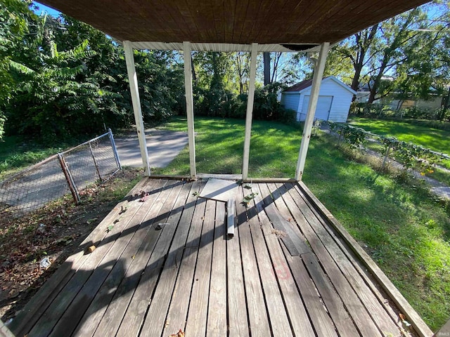 wooden deck featuring an outbuilding and a lawn